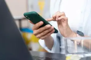 Oseba drži v roki pametni telefon