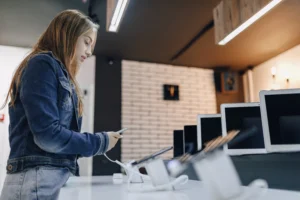 Oseba v trgovini izbira telefon in se odloča za predplačniški paket brez vezave